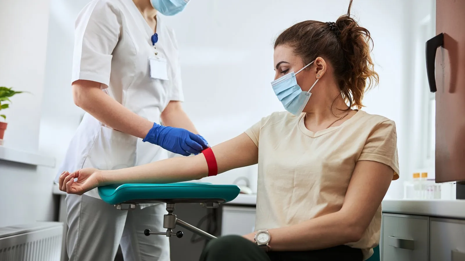 Profissional de laboratório fazendo coleta de sangue em um paciente